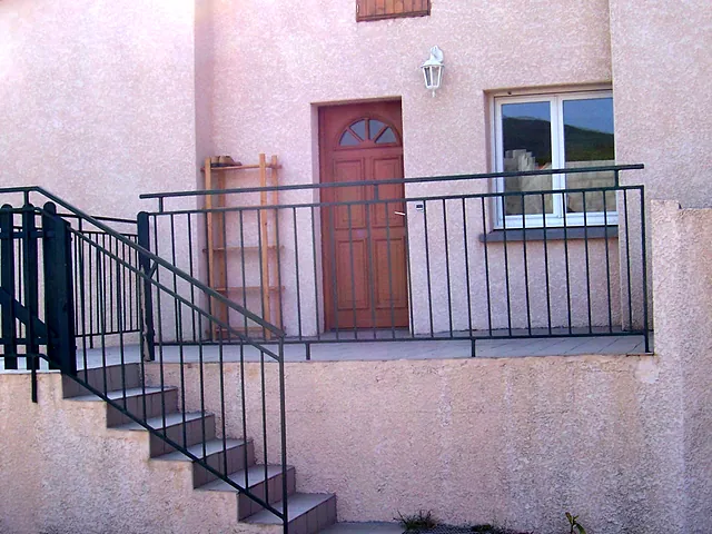 Façade d’un T3 : escalier extérieur, terrasse et porte d’entrée